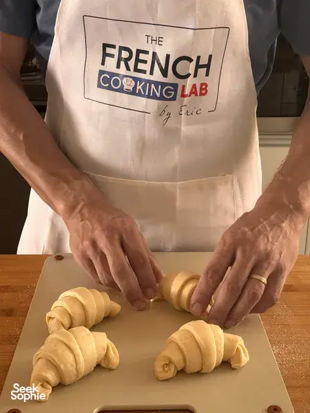 Di bengkel di Singapura, tangan pembuat roti French Cooking Lab menggulung doh croissant di atas papan kayu, sedia untuk dibakar