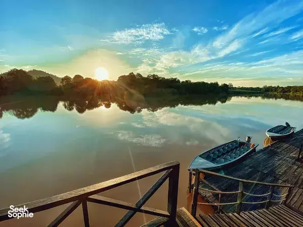 Wooden jetty with a long-tail boat at sunset near Sandakan during the 3D2N safari on Kinabatangan River