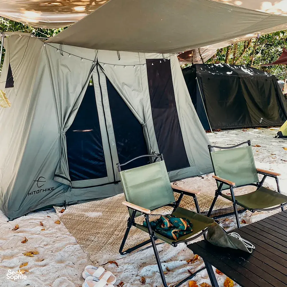 Beach camping setup on Surin Island: dome tent, folding chairs and a small table under a shaded canopy by the sand