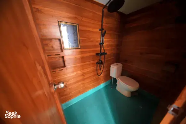 Travass Life 3D2N join-in Komodo trip cabin bathroom with toilet, hand shower and wooden walls, Labuan Bajo