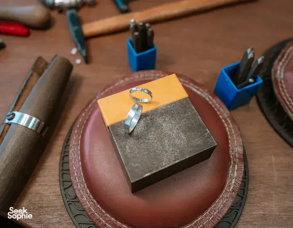 Silver ring on a maker’s leather tray and tools laid out on the bench at Fat Anvil Studios in Singapore couple ring workshop