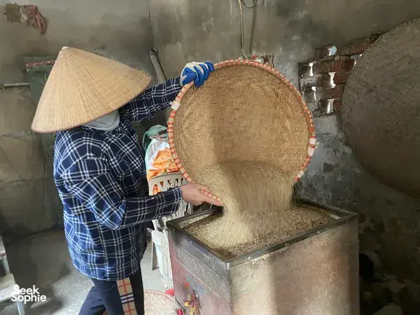 在河内红河村，传统豆腐制作过程中，编织竹滤篮斜靠在金属压模上，豆渣正慢慢沥干