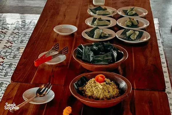Vegan Balinese cooking class lunch set out on a wooden table at Anandinii Organic Garden & Kitchen in Sidemen, Bali, with bowls and plates