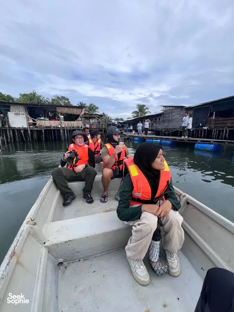 Private tour on a riverboat in Johor Bahru with Young Nautilus educators, guests watching coastal waters past stilt houses