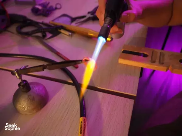 Torch flame heating metal on a bench during The Imperial Smithster’s silversmithing workshop in Singapore — workshops in Singapore