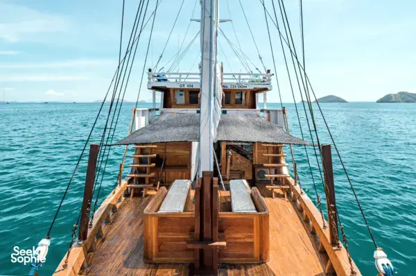 Wooden bow deck of a sleek white phinisi with open sail lines and horizon view during a private 3D2N Komodo cruise in Labuan Bajo