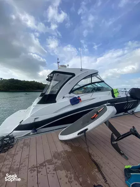 White speedboat docked by a jetty in Singapore, with watersports gear strapped along the deck for jetboard and efoil