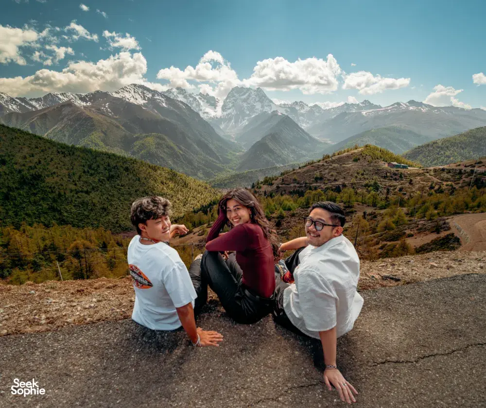 Travellers posing on a mountain viewpoint during the Shangri-La Loop with a Tibetan guide in Shangri-La