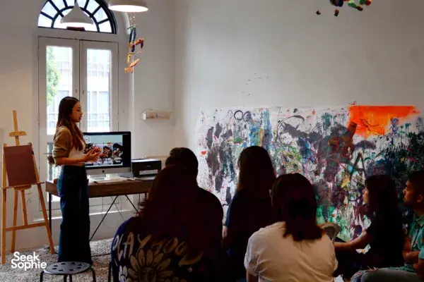 Instructor demonstrating butter crafting to a seated group in a sunlit studio in Singapore, workshops in Singapore
