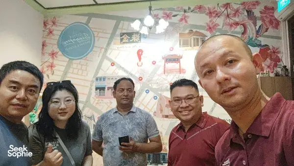 Group smiling indoors in a shop during a real-life Monopoly team route in Katong-Joo Chiat, Singapore hidden gems