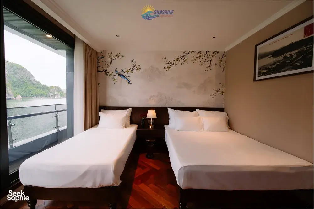 Sunshine Golden Cruises twin cabin on a Cat Ba cruise with two beds and floor-to-ceiling window overlooking the bay