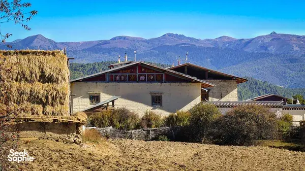 Ferme Liotard guest house in Shangri-La with Tibetan-style architecture and views over a high-altitude mountain valley