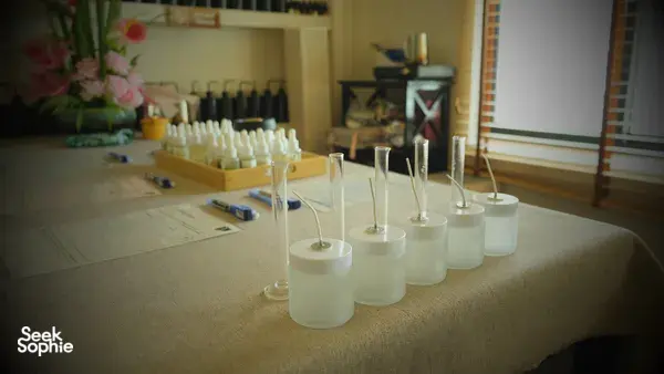 White coco-soy candle jars lined on a table in Singapore, ready for custom scent blending at a perfume workshop