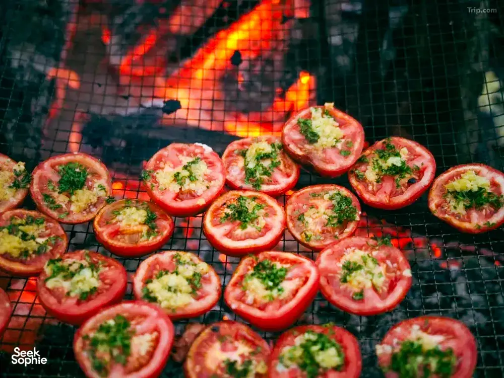 Halved tomatoes with herbs grilling on a camp barbecue during a 2D2N Tibetan valley stay with Caravan Treks by Ferme Liotard in Shangri-La