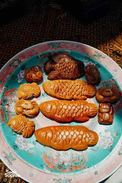 Assorted traditional kueh on a turquoise plate during a Singapore home kueh-making session — workshops in Singapore