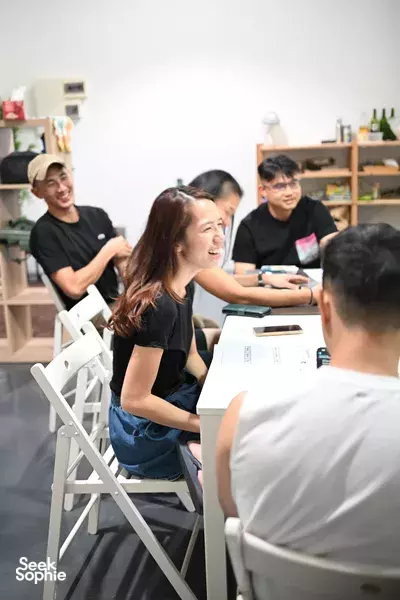 Team workshop in Singapore where participants chat and cook at shared tables, learning garden-to-table methods