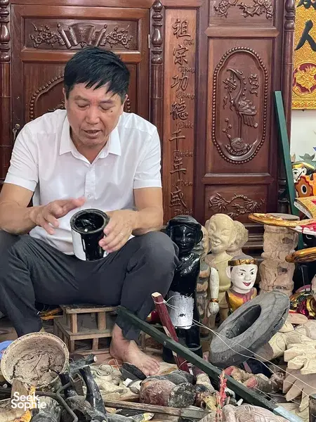 Seorang dalang generasi ketujuh mengerjakan kerajinan boneka air di studio di Hanoi, merakit boneka-boneka yang sudah dicat di antara peralatan dan kepala boneka