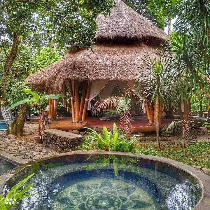 Thatched meditation pavilion and outdoor plunge pool at Omunity Bali retreat in lush garden courtyards, Bali