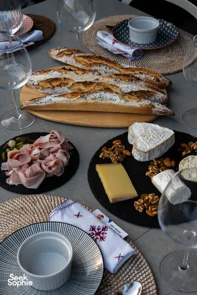 Sliced French baguettes on a wooden board with cheese, ham and nuts on a Singapore loft table for private dining Singapore