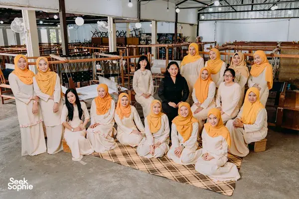 Group of women in headscarves posing with woven textiles and handlooms after a Tanoti Crafts workshop in Kuching