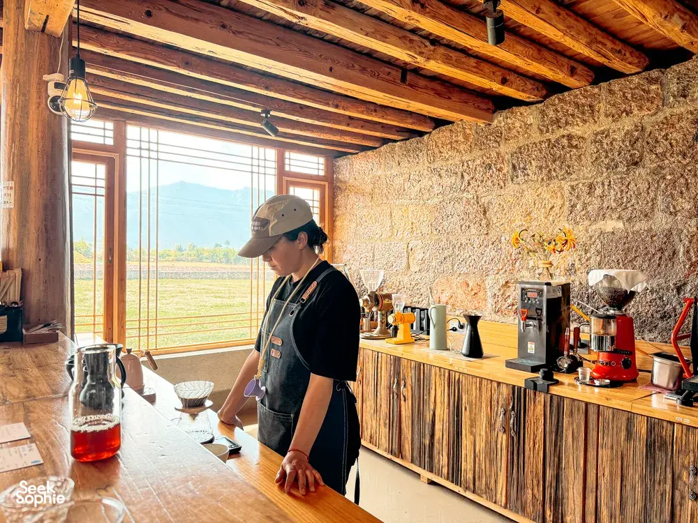 Seeker Yunnan Coffee Estate workshop in Lijiang, a host preparing specialty coffee beside brewing equipment and glass carafes