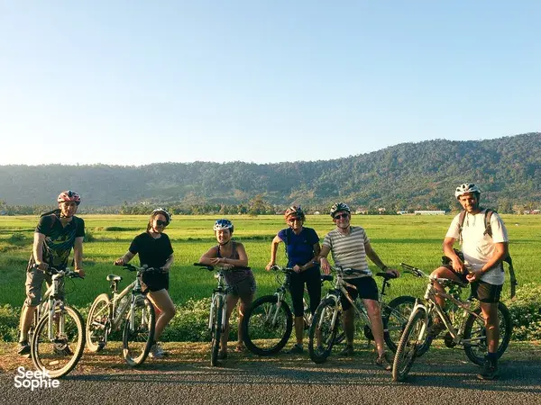 Cyclists pausing with their bikes on a scenic road through Langkawi countryside during a villages, markets and jetty ride