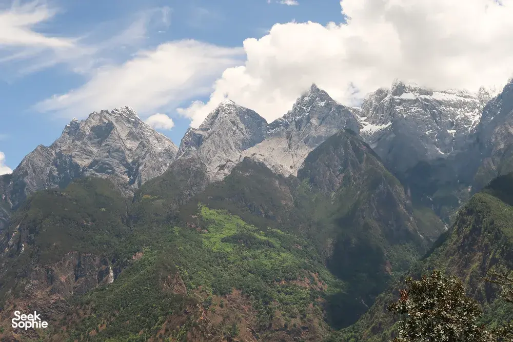 Snowy mountain peaks and a green valley view over Tiger Leaping Gorge, Lijiang, on the high-trail trek