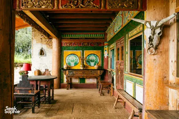 Traditional Tibetan-style dining room with carved furniture and colourful murals at a Mission Liotard base near Shangri-La