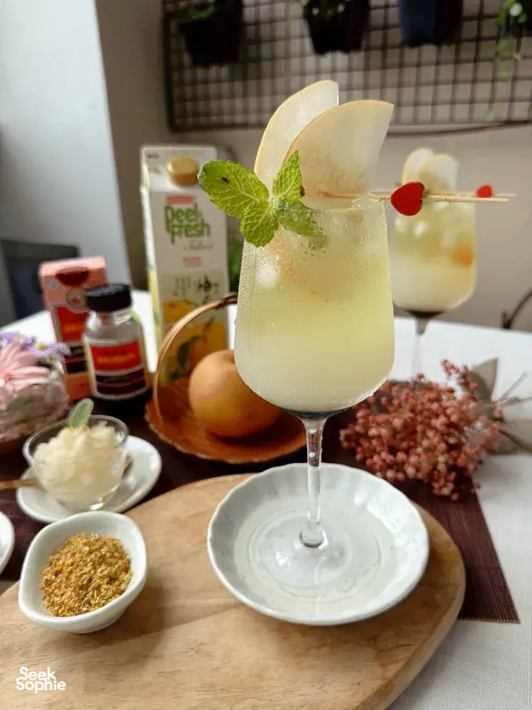 Two TCM-inspired mocktails with mint and red berry garnish, plus herb bowls and ingredients on a wooden table—workshops in Singapore