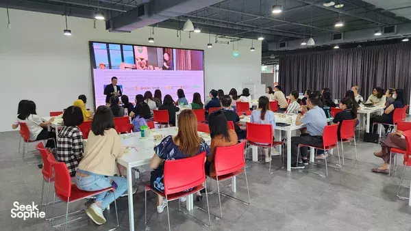 Facilitator leading a workshop in Singapore as participants watch a slideshow on screen for team bonding activities Singapore