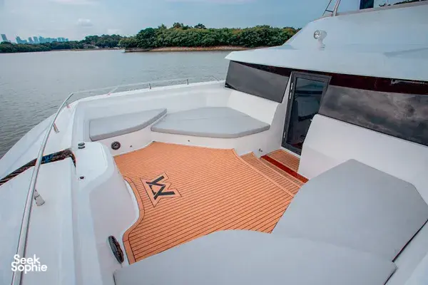 MS Eternity catamaran sun deck with white cushions and orange teak flooring, cruising across Singapore waters towards Lazarus Island