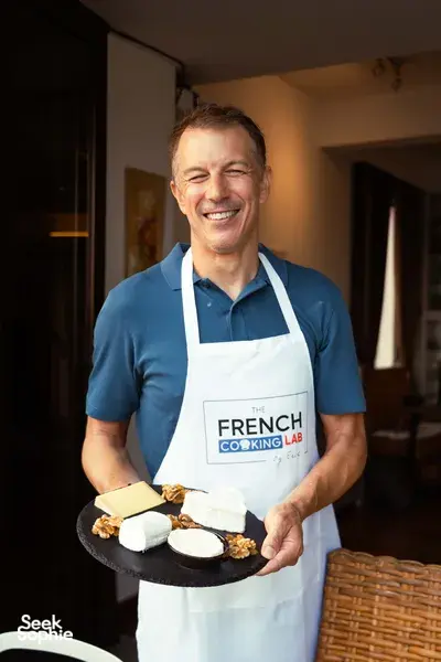 Eric at French Cooking Lab holding a plate of French baguette-style bites and pastries inside the cosy Singapore loft