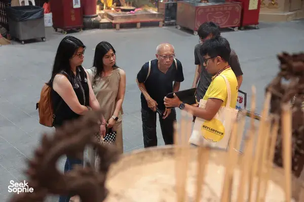 Hey Lad Tour guide chatting with visitors in a temple courtyard during Hidden Chinese Rituals at night in Singapore, Singapore hidden gems