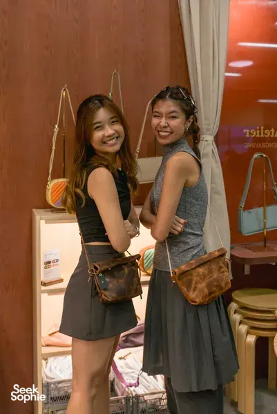 Participants smiling with handmade leather bags at Crafune leathercraft studio in Singapore—workshops in Singapore