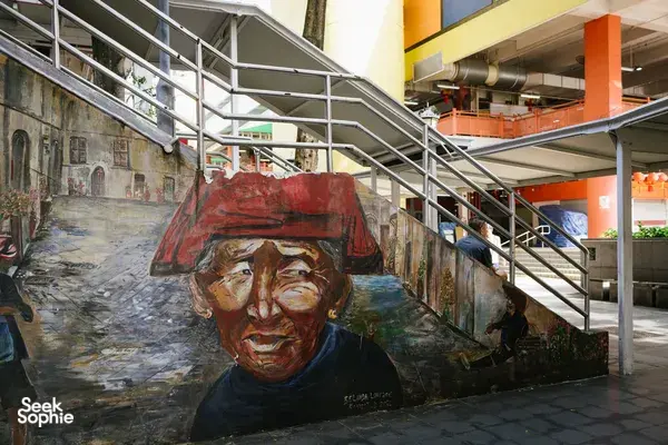 Street mural in Singapore Chinatown alley under a covered walkway, featuring a painted portrait as your team explores Singapore hidden gems