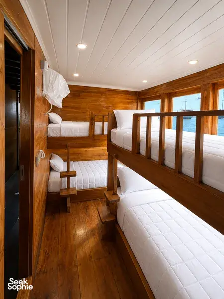 Wooden phinisi cabin with fitted bunk beds on a 3D2N shared wood-panelled cruise from Labuan Bajo, Komodo Island