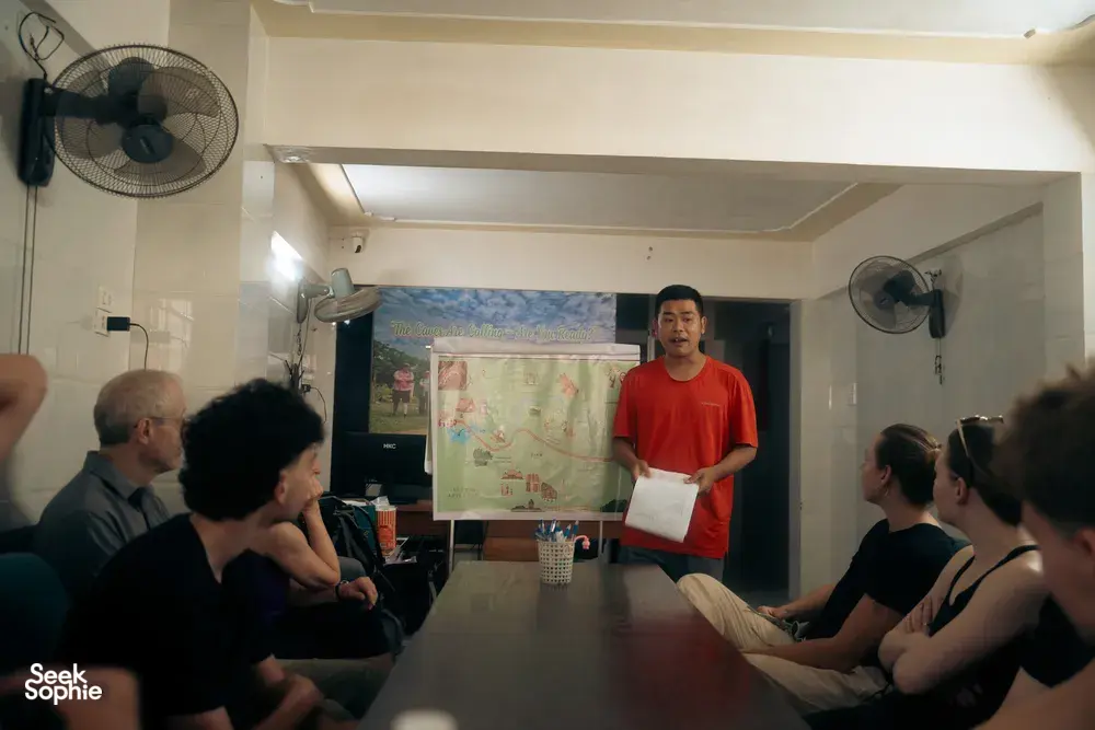 Greenland Tours guide briefing travellers at a table with a wall map in Phong Nha, ready for the cave experience