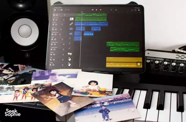 Audio mixing on a computer screen with photo montage cards, speakers and MIDI gear at SmallGiant Music workshops in Singapore