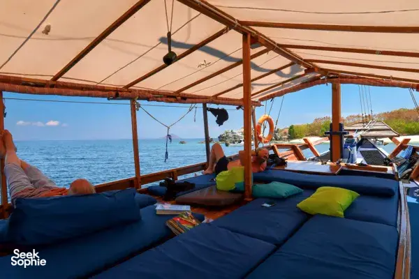 Relaxing on the covered deck of a liveaboard boat during a 3D2N Komodo dive cruise from Labuan Bajo over open sea