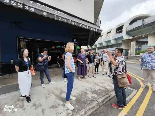 Small group listening near a shophouse on Indie Singapore Tours’ private night walk through Geylang, Singapore hidden gems