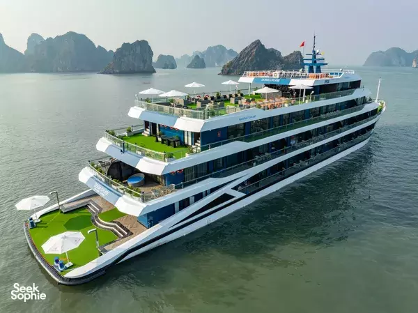 Doria Cruise 5-star Lan Ha Bay cruise ship with green sun deck, aerial view across calm Halong Bay waters