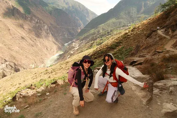 Backpackers hiking along a dirt trail with wide valley views in Tiger Leaping Gorge, Lijiang, on the 2D1N high trail