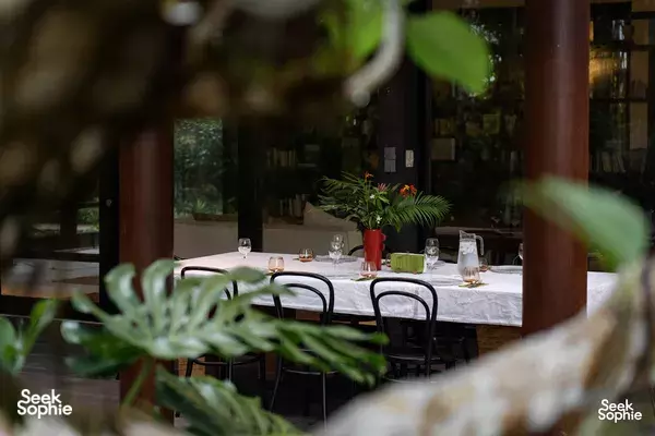 Set dining table beneath a Balinese villa canopy overlooking rainforest greenery in Singapore, styled for a private dining Singapore feast