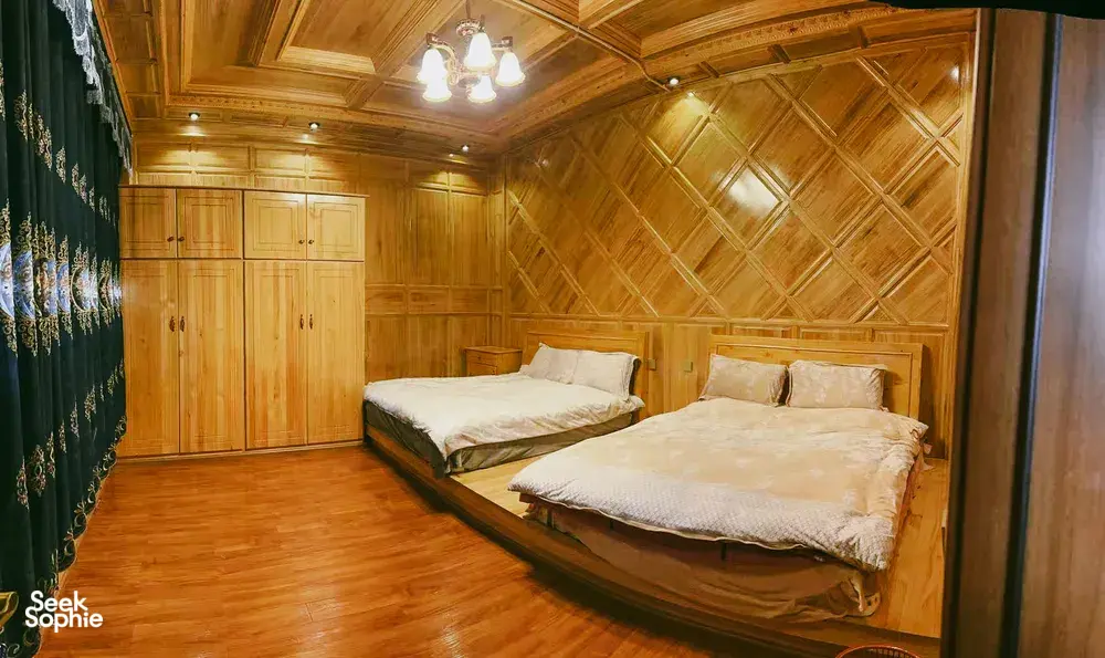 Wooden guest room with two beds at a Tibetan family homestay in Shangri-La on a Khampa Caravan 2D2N stay