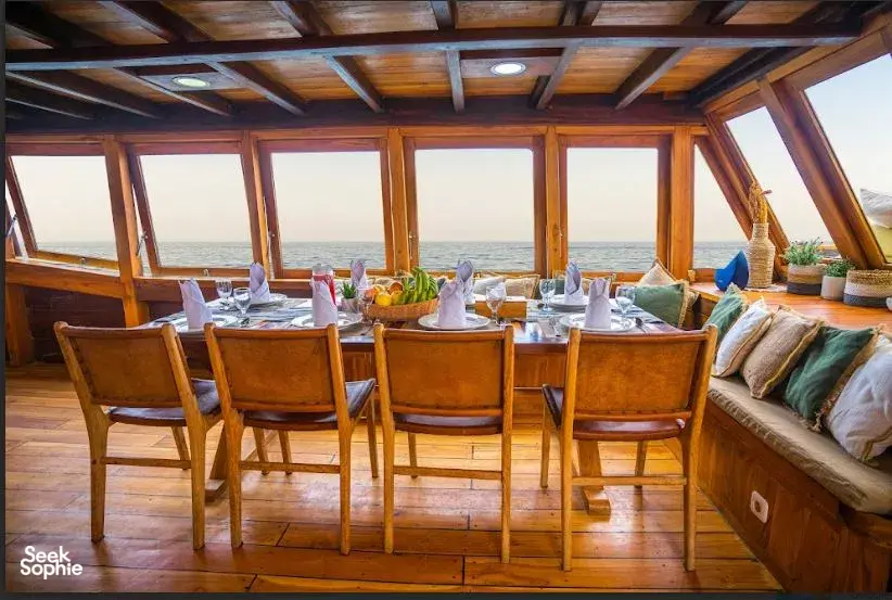 Breakfast dining set in a luxury phinisi lounge with sea views on a 3D2N private Komodo liveaboard in Labuan Bajo