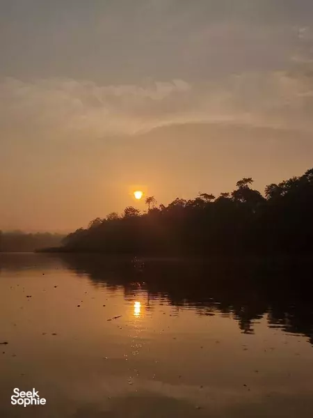 Sunset over a slow river through misty jungle on a hilltop lodge stay at The Last Frontier Boutique Resort near the Kinabatangan River
