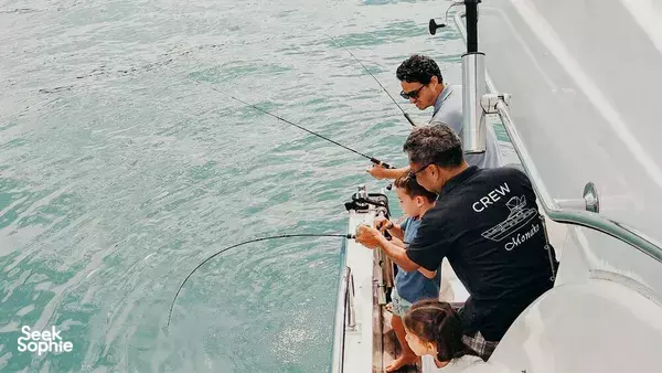 Crew on the Monako yacht on Singapore waters casting fishing lines from the stern during a 4-hour Japanese BBQ and KTV trip