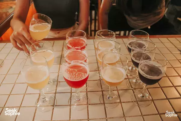 Flight of small craft beer glasses laid out on a tiled table at Lion Brewery Co brewpub in Singapore for the tour