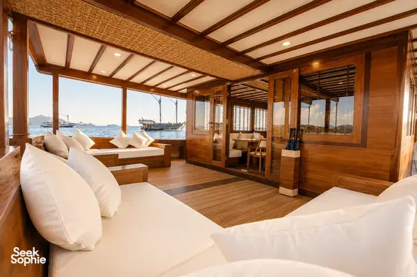 Wooden lounge on a new phinisi with sea views, for a rare 3D2N shared trip in Labuan Bajo waters around Komodo Island