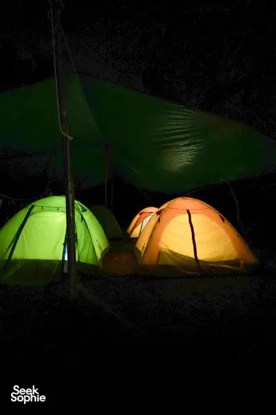 Night camping in Phong Nha with glowing green and orange tents during a 2D1N hike, paddle and caves adventure